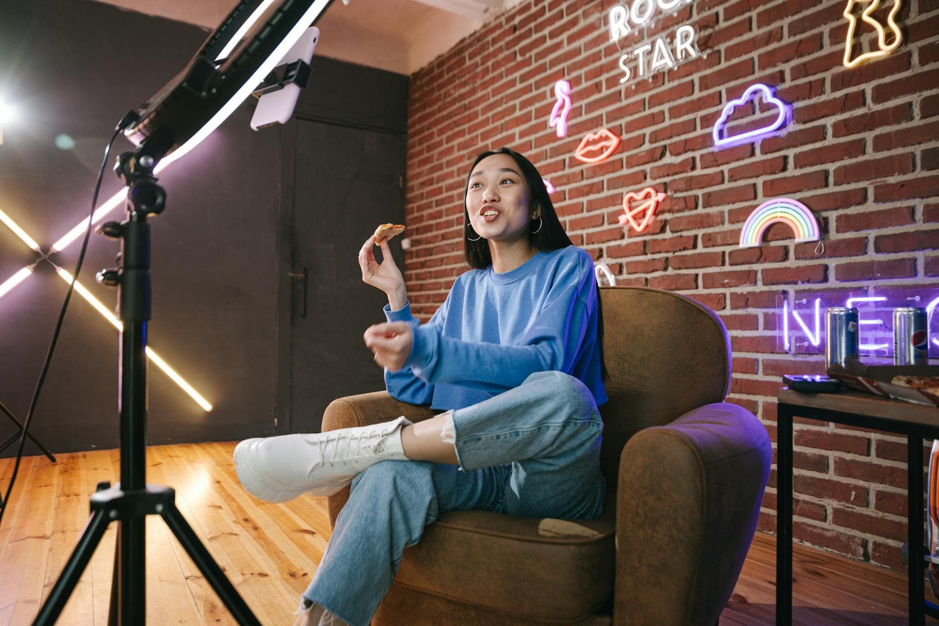 Creator filming a live podcast stream with ring light and studio video setup