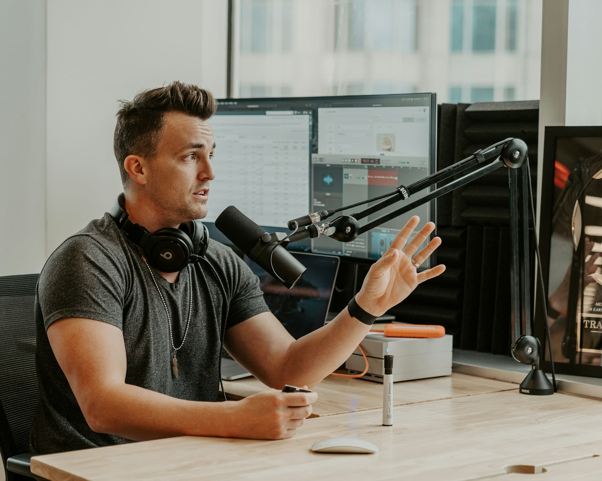 Podcast host recording at a microphone for an audio versus video podcast guide