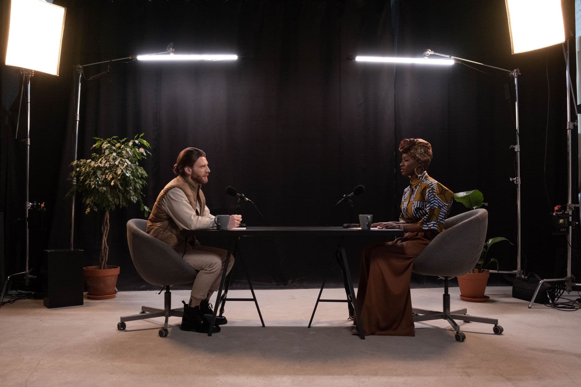 Two guests recording an interview podcast on a professional studio set