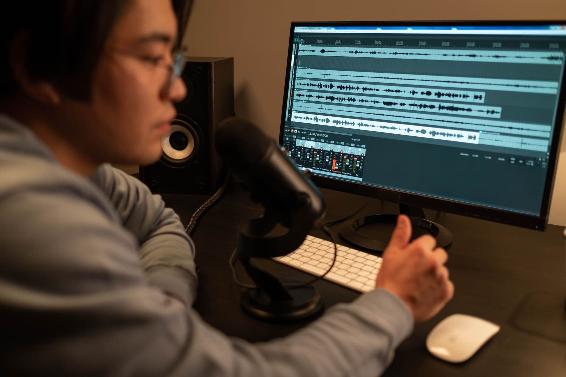 Podcast editor reviewing multiple audio tracks at a post-production workstation